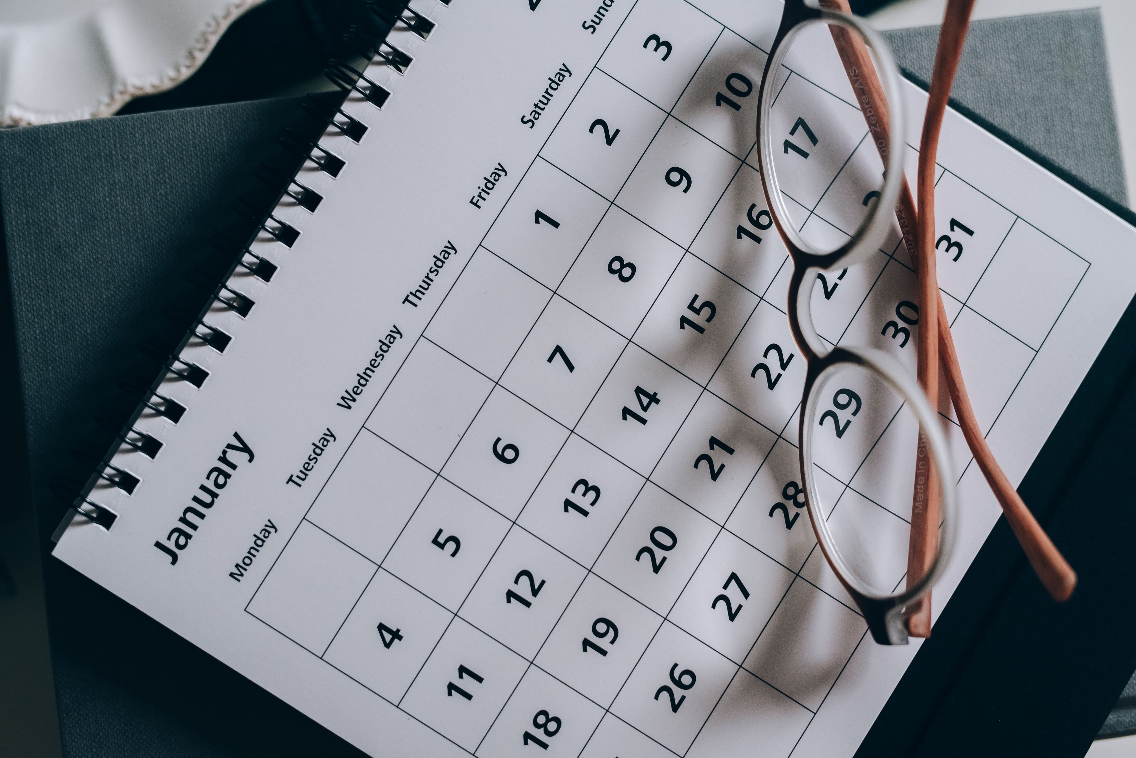 A January desk calendar with a pair of reading glasses