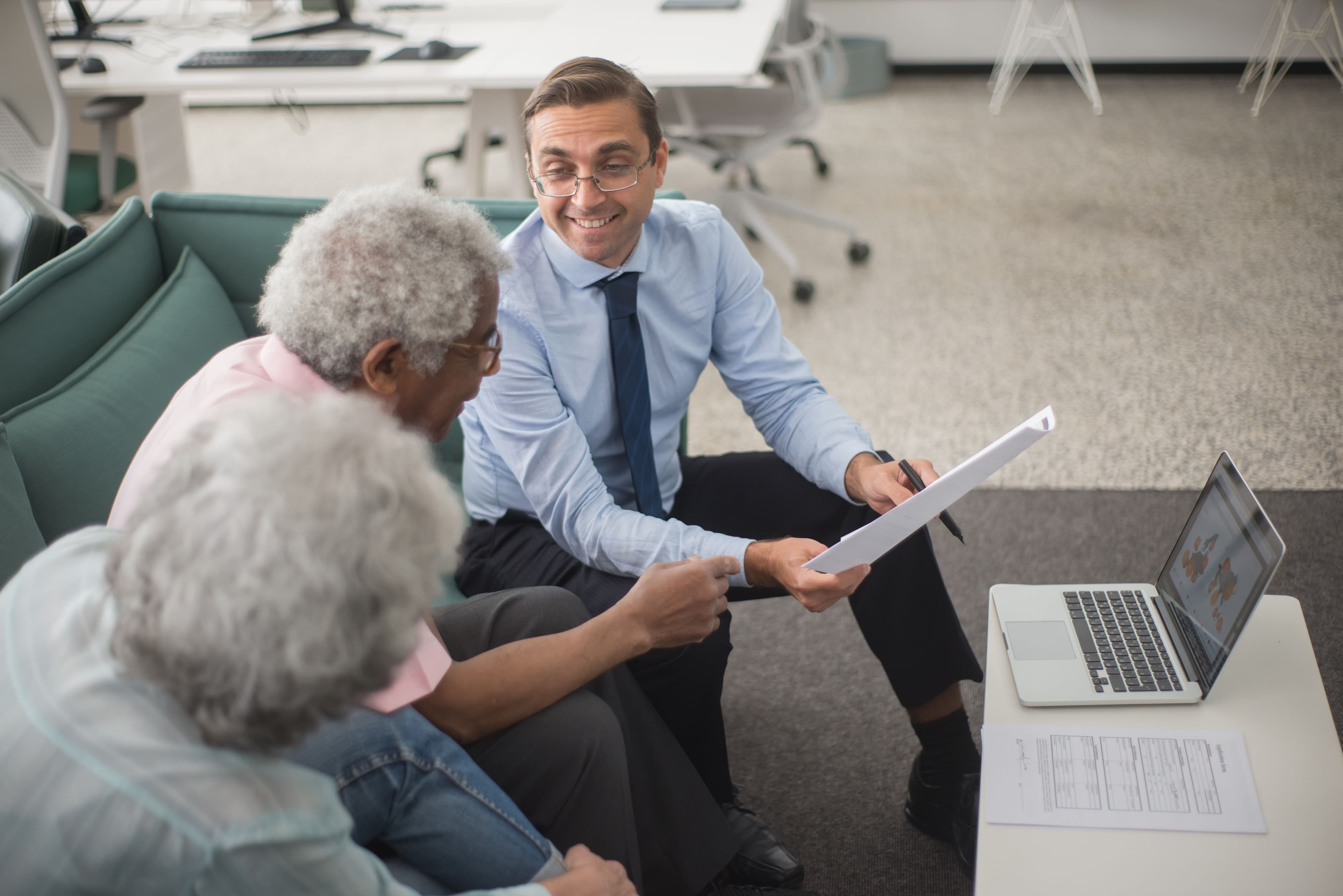An older couple reviewing documents with a financial advisor